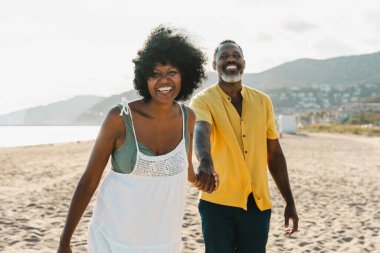 Güzel, olgun, siyahi çift deniz kenarında flört ediyor evli, orta yaşlı çift dışarıda eğleniyor, ilişki, yaşam tarzı ve yaşam kalitesi kavramları.