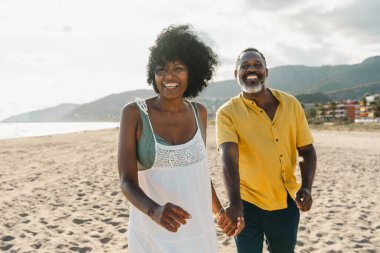 Güzel, olgun, siyahi çift deniz kenarında flört ediyor evli, orta yaşlı çift dışarıda eğleniyor, ilişki, yaşam tarzı ve yaşam kalitesi kavramları.
