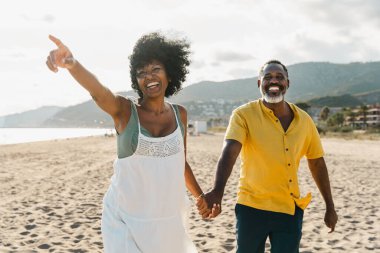 Güzel, olgun, siyahi çift deniz kenarında flört ediyor evli, orta yaşlı çift dışarıda eğleniyor, ilişki, yaşam tarzı ve yaşam kalitesi kavramları.
