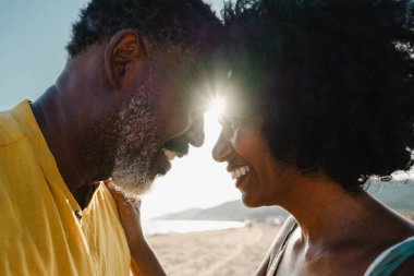 Güzel, olgun, siyahi çift deniz kenarında flört ediyor evli, orta yaşlı çift dışarıda eğleniyor, ilişki, yaşam tarzı ve yaşam kalitesi kavramları.