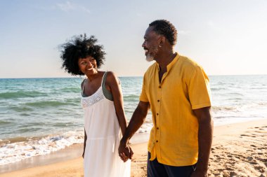 Güzel, olgun, siyahi çift deniz kenarında flört ediyor evli, orta yaşlı çift dışarıda eğleniyor, ilişki, yaşam tarzı ve yaşam kalitesi kavramları.