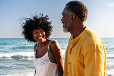 Güzel, olgun, siyahi çift deniz kenarında flört ediyor evli, orta yaşlı çift dışarıda eğleniyor, ilişki, yaşam tarzı ve yaşam kalitesi kavramları.