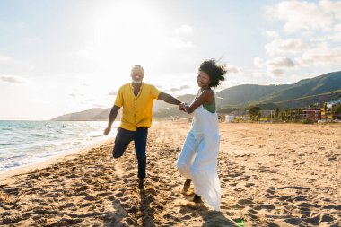 Güzel, olgun, siyahi çift deniz kenarında flört ediyor evli, orta yaşlı çift dışarıda eğleniyor, ilişki, yaşam tarzı ve yaşam kalitesi kavramları.