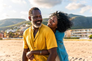 Güzel, olgun, siyahi çift deniz kenarında flört ediyor evli, orta yaşlı çift dışarıda eğleniyor, ilişki, yaşam tarzı ve yaşam kalitesi kavramları.