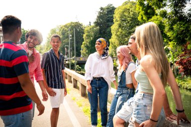 Çok ırklı bir grup genç dışarıda vakit geçirip eğleniyor. Z kuşağı, yaşam tarzı ve arkadaşlık kavramları