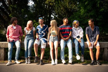 Çok ırklı bir grup genç dışarıda vakit geçirip eğleniyor. Z kuşağı, yaşam tarzı ve arkadaşlık kavramları
