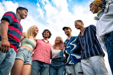 Çok ırklı bir grup genç parkta piknik yapmak için dışarıda zaman geçiriyorlar. Z kuşağı, yaşam tarzı ve arkadaşlık kavramları