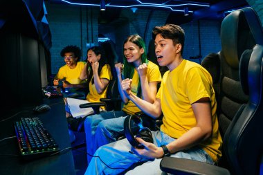 Video oyunları oynayan çok ırklı bir grup genç arkadaş - Sanal oyunlar turnuvasında rekabetçi video oyunlarında oynayan profesyonel esport oyuncuları takımı