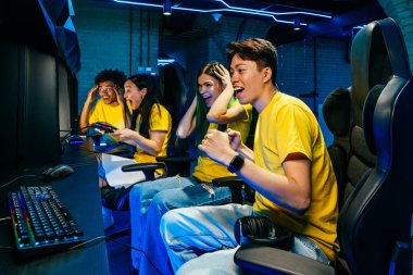 Video oyunları oynayan çok ırklı bir grup genç arkadaş - Sanal oyunlar turnuvasında rekabetçi video oyunlarında oynayan profesyonel esport oyuncuları takımı