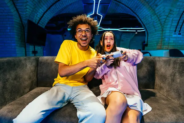 ソファーに座って自宅でビデオゲームをプレイする若い友人の複数のグループ コンピュータのビデオゲームコンソールでEスポーツをする楽しいビデオゲーム — ストック写真