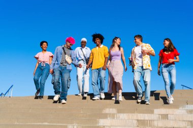 Çok ırklı, mutlu bir grup genç arkadaş şehirde takılıyor - çok ırklı bir grup öğrenci buluşuyor ve dışarıda eğleniyor, gençlik, gençlik, çeşitlilik ve yaşam tarzı kavramları hakkında