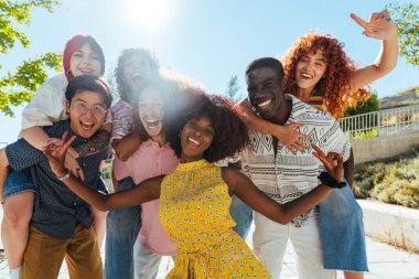 Çok ırklı bir grup genç arkadaş buluşuyor ve dışarıda eğleniyorlar- çok ırklı mutlu ve şık genç öğrenciler şehirde kaynaşıyor, gençlik kavramları, gençlerin yaşam tarzı ve çeşitliliği