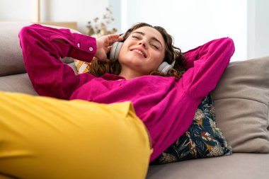 Evde renkli giysileri olan güzel genç bir kadın neşeli, güzel, yetişkin bir kadın evde kaliteli zaman geçiriyor.