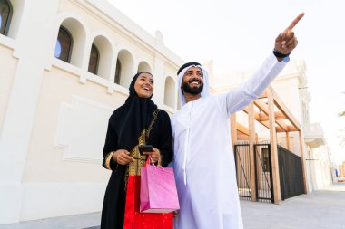 Geleneksel Arap çift açık havada buluşan emirati kıyafetleri giyiyorlar - Orta Doğulu evli kadın ve abaya ile erkek kandura buluşması ve şehirde eğleniyorlar