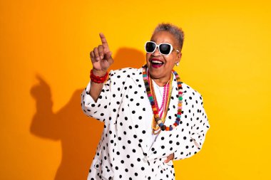 Stüdyoda izole edilmiş şık kıyafetler giyen komik yaşlı siyahi kadının renkli portresi - havalı yaşlı kadın yetişkin, yaşlılar, yaşlılar ve vücut pozitifliği kavramları