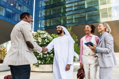 Çok ırklı iş adamlarından oluşan bir grup emirati 'li bir işadamıyla buluşuyor.