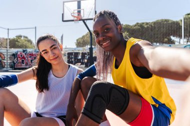 Çok ırklı bayan basketbol oyuncuları şehir basketbol sahasında antrenman yapıyor - açık havada basketbol oynayan atletik kadınlar, spor, yaşam tarzı ve cinsiyet eşitliği kavramları
