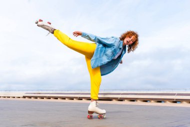 Güzel, kızıl saçlı, patenli, dışarıda eğlenen genç bir kadın şehirde paten sürerken kendine has bir tarzı olan güzel bir genç kız.