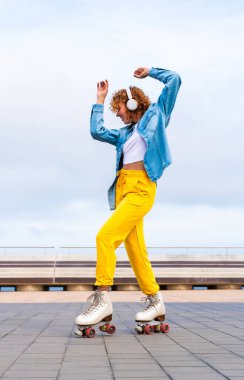 Güzel, kızıl saçlı, patenli, dışarıda eğlenen genç bir kadın şehirde paten sürerken kendine has bir tarzı olan güzel bir genç kız.