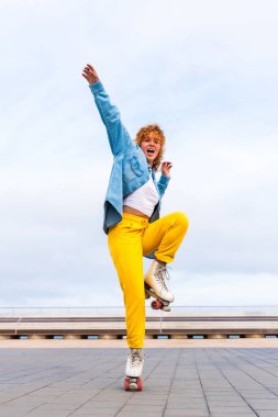 Güzel, kızıl saçlı, patenli, dışarıda eğlenen genç bir kadın şehirde paten sürerken kendine has bir tarzı olan güzel bir genç kız.