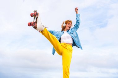 Güzel, kızıl saçlı, patenli, dışarıda eğlenen genç bir kadın şehirde paten sürerken kendine has bir tarzı olan güzel bir genç kız.