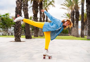 Güzel, kızıl saçlı, patenli, dışarıda eğlenen genç bir kadın şehirde paten sürerken kendine has bir tarzı olan güzel bir genç kız.