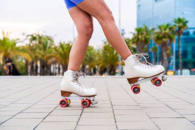 Güzel, kızıl saçlı, patenli, dışarıda eğlenen genç bir kadın şehirde paten sürerken kendine has bir tarzı olan güzel bir genç kız.