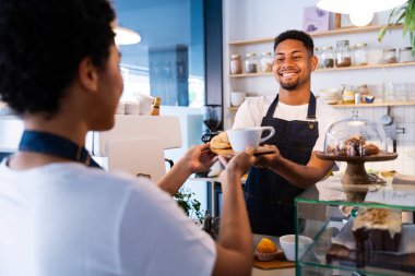 Pastane, kafede hamur işi, kahve ve fırında yemek servisi yapmaya hazır zenci erkek ve kadının mutlu portresi. Servis için tezgah, yardım ve bir kahve dükkanına hoş geldiniz.