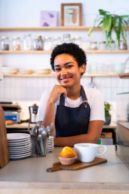 Fırın, kafedeki siyah kadının mutlu portresi pasta, kahve ve pişmiş yiyecekler servis etmeye hazır. Restoran, kafe ve kendine güvenen garson barista servis, yardım ve hoş geldiniz.