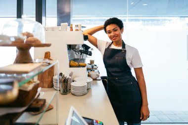 Fırın, kafedeki siyah kadının mutlu portresi pasta, kahve ve pişmiş yiyecekler servis etmeye hazır. Restoran, kafe ve kendine güvenen garson barista servis, yardım ve hoş geldiniz.