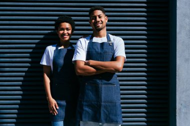 Pastane, kafede hamur işi, kahve ve fırında yemek servisi yapmaya hazır zenci erkek ve kadının mutlu portresi. Servis için tezgah, yardım ve bir kahve dükkanına hoş geldiniz.