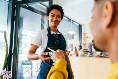 Fırın, kafedeki siyah kadının mutlu portresi pasta, kahve ve pişmiş yiyecekler servis etmeye hazır. Restoran, kafe ve kendine güvenen garson barista servis, yardım ve hoş geldiniz.