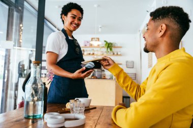 Fırın, kafedeki siyah kadının mutlu portresi pasta, kahve ve pişmiş yiyecekler servis etmeye hazır. Restoran, kafe ve kendine güvenen garson barista servis, yardım ve hoş geldiniz.