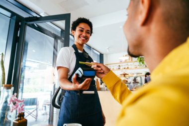 Fırın, kafedeki siyah kadının mutlu portresi pasta, kahve ve pişmiş yiyecekler servis etmeye hazır. Restoran, kafe ve kendine güvenen garson barista servis, yardım ve hoş geldiniz.