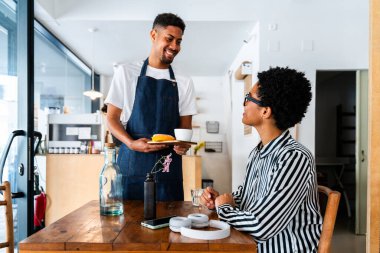 Fırın, kafede hamur işi, kahve ve fırında yemek servisi için hazır İspanyol siyahi bir adamın mutlu portresi. Restoran, kafe ve kendine güvenen garson barista servis, yardım ve hoş geldiniz.