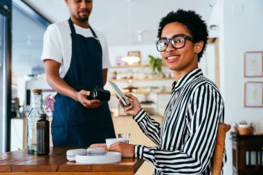 Fırın, kafede hamur işi, kahve ve fırında yemek servisi için hazır İspanyol siyahi bir adamın mutlu portresi. Restoran, kafe ve kendine güvenen garson barista servis, yardım ve hoş geldiniz.