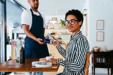Fırın, kafede hamur işi, kahve ve fırında yemek servisi için hazır İspanyol siyahi bir adamın mutlu portresi. Restoran, kafe ve kendine güvenen garson barista servis, yardım ve hoş geldiniz.