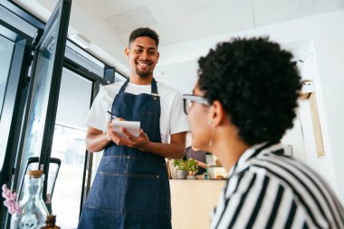 Fırın, kafede hamur işi, kahve ve fırında yemek servisi için hazır İspanyol siyahi bir adamın mutlu portresi. Restoran, kafe ve kendine güvenen garson barista servis, yardım ve hoş geldiniz.