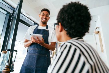 Fırın, kafede hamur işi, kahve ve fırında yemek servisi için hazır İspanyol siyahi bir adamın mutlu portresi. Restoran, kafe ve kendine güvenen garson barista servis, yardım ve hoş geldiniz.