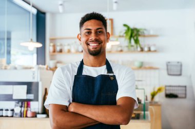 Fırın, kafede hamur işi, kahve ve fırında yemek servisi için hazır İspanyol siyahi bir adamın mutlu portresi. Restoran, kafe ve kendine güvenen garson barista servis, yardım ve hoş geldiniz.