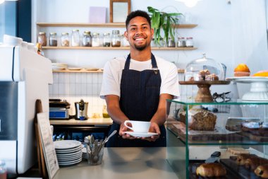 Fırın, kafede hamur işi, kahve ve fırında yemek servisi için hazır İspanyol siyahi bir adamın mutlu portresi. Restoran, kafe ve kendine güvenen garson barista servis, yardım ve hoş geldiniz.