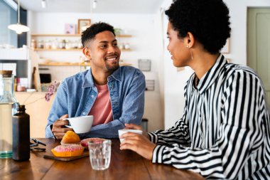 Güzel, genç, melez bir çift, bir bar kafeteryasında oturuyor, Afro-Amerikan arkadaşları bir pastanede dinleniyorlar.