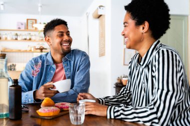Güzel, genç, melez bir çift, bir bar kafeteryasında oturuyor, Afro-Amerikan arkadaşları bir pastanede dinleniyorlar.