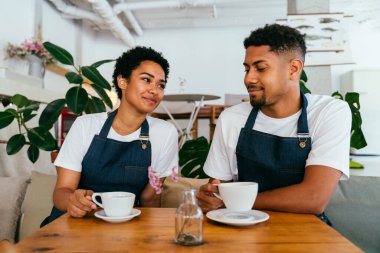 Pastane, kafede hamur işi, kahve ve fırında yemek servisi yapmaya hazır zenci erkek ve kadının mutlu portresi. Servis için tezgah, yardım ve bir kahve dükkanına hoş geldiniz.
