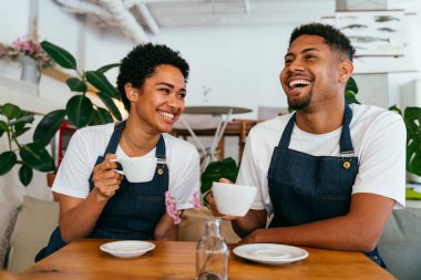 Pastane, kafede hamur işi, kahve ve fırında yemek servisi yapmaya hazır zenci erkek ve kadının mutlu portresi. Servis için tezgah, yardım ve bir kahve dükkanına hoş geldiniz.