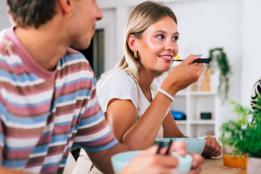 Çok ırklı bir grup genç arkadaş evde buluşuyor ve yemek yerken çok ırklı ve mutlu insanlar yemek yiyor.