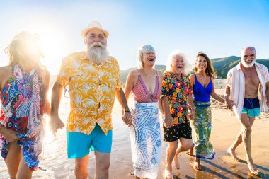 Yaz boyunca sahilde kaynaşan mutlu, yaşlı ve neşeli insanlar yaz tatilinde denizde eğleniyorlar, yaşlılar yaşam tarzı kavramları.