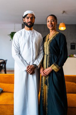 Emirati kıyafetleriyle mutlu, genç, güzel bir Arap çift. Geleneksel Arap kıyafetli, Orta Doğulu bir erkek ve bir kadın.