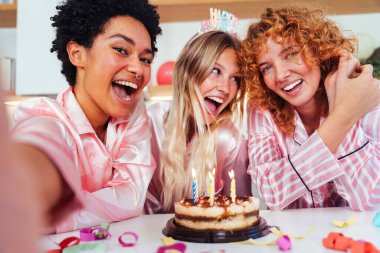 Evde pijama partisi veren çok ırklı bir grup genç kız arkadaş neşeli en iyi kız arkadaşlar kaynaşıyor ve evde eğleniyorlar.