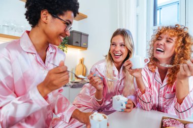 Evde pijama partisi veren çok ırklı bir grup genç kız arkadaş neşeli en iyi kız arkadaşlar kaynaşıyor ve evde eğleniyorlar.